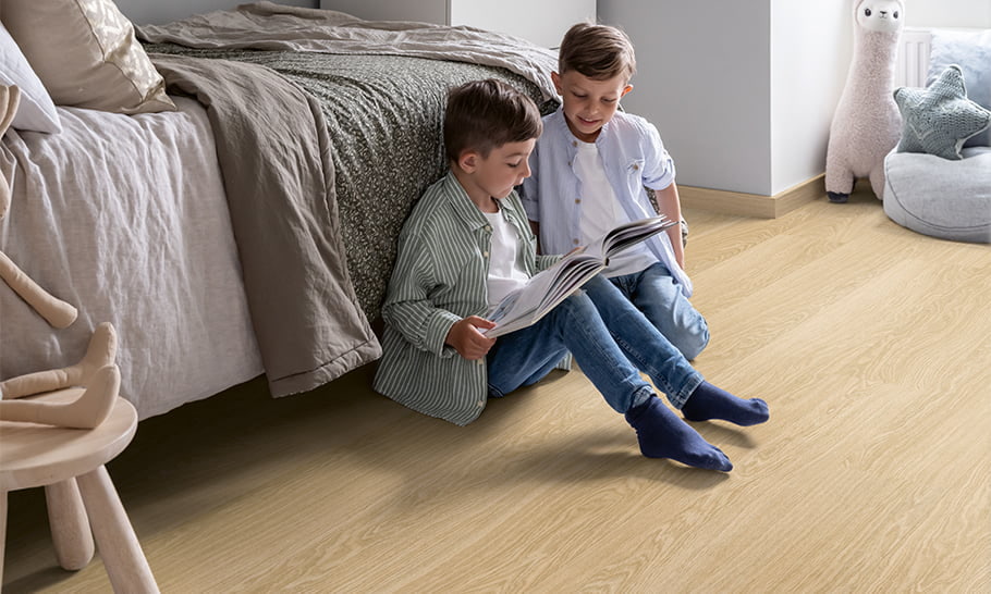 two kids playing on beige vinyl floor in bedroom